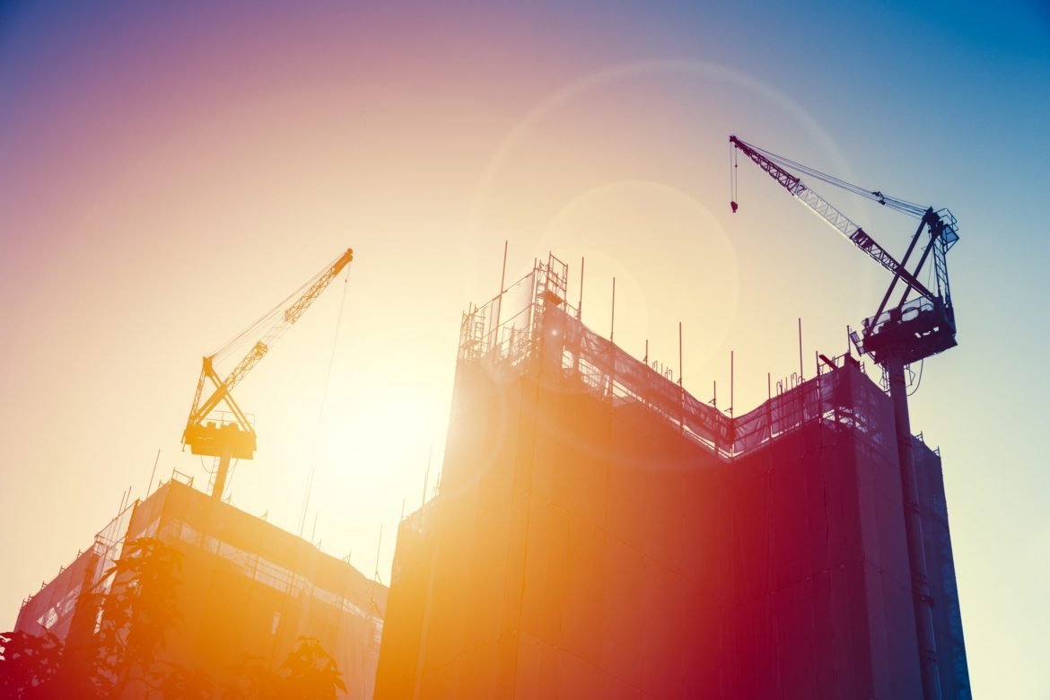 Two cranes working on the construction of high-rise buildings