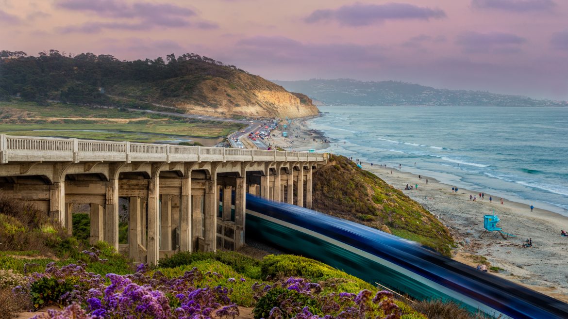 A high-speed train travelling by a beach in California