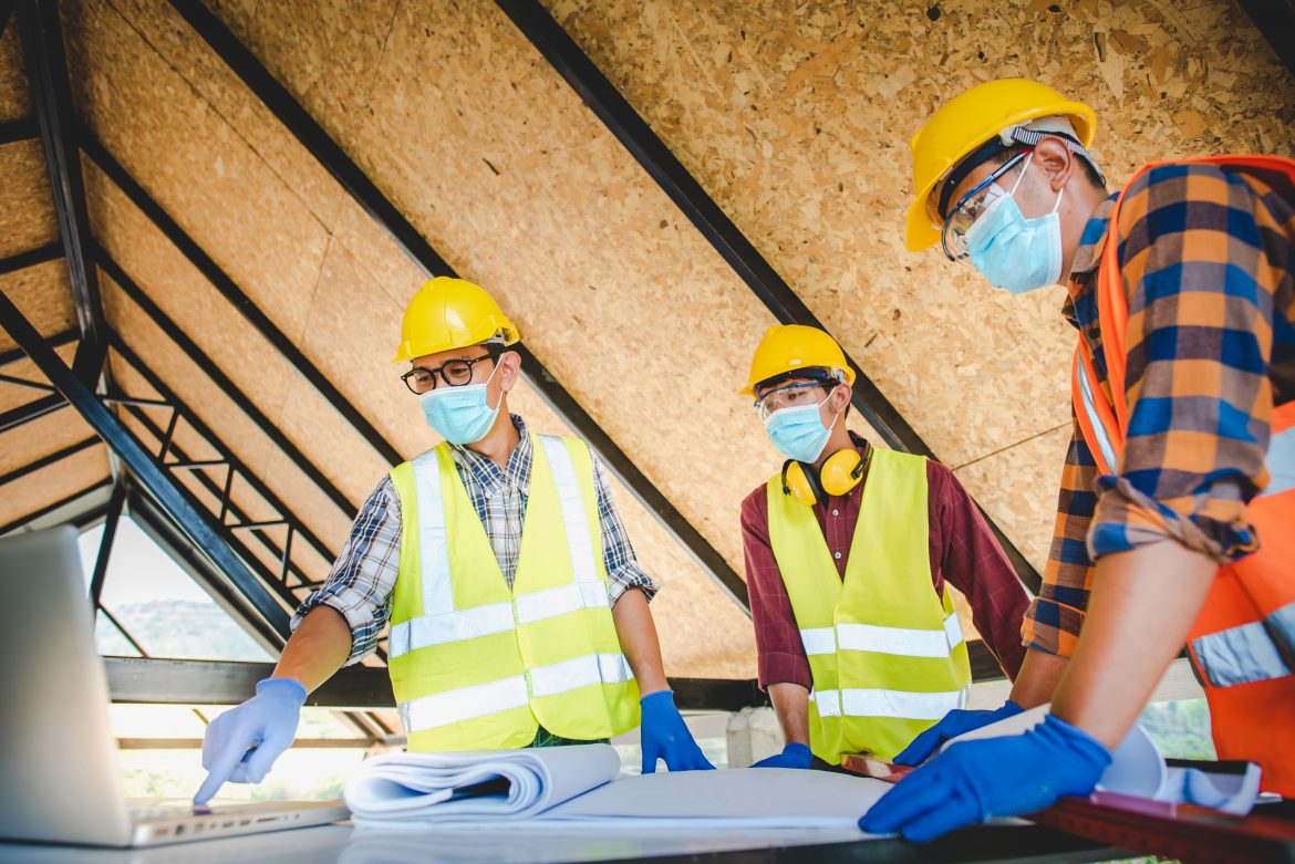 Builders on a construction site wearing COVID-19 facemasks
