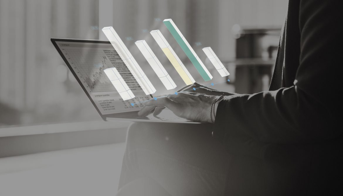 A man on a laptop with a bar chart coming out of the screen