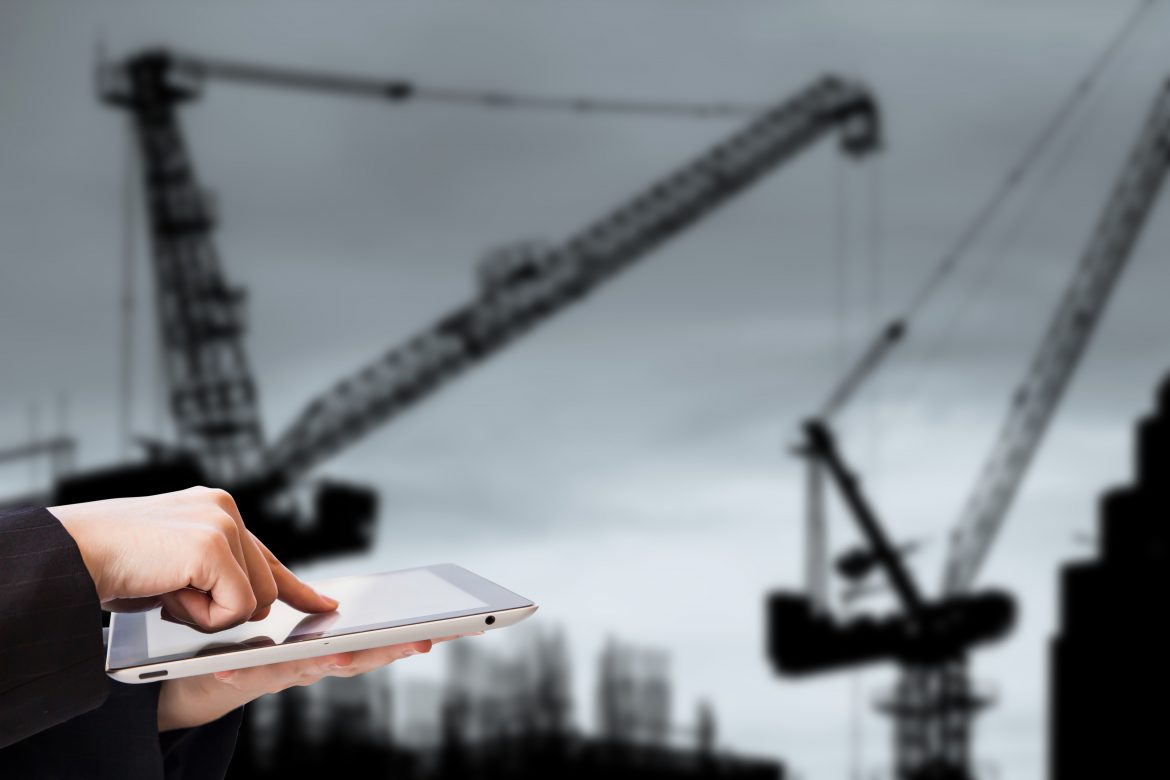 A businesswoman using a tablet amid a gloomy construction backdrop