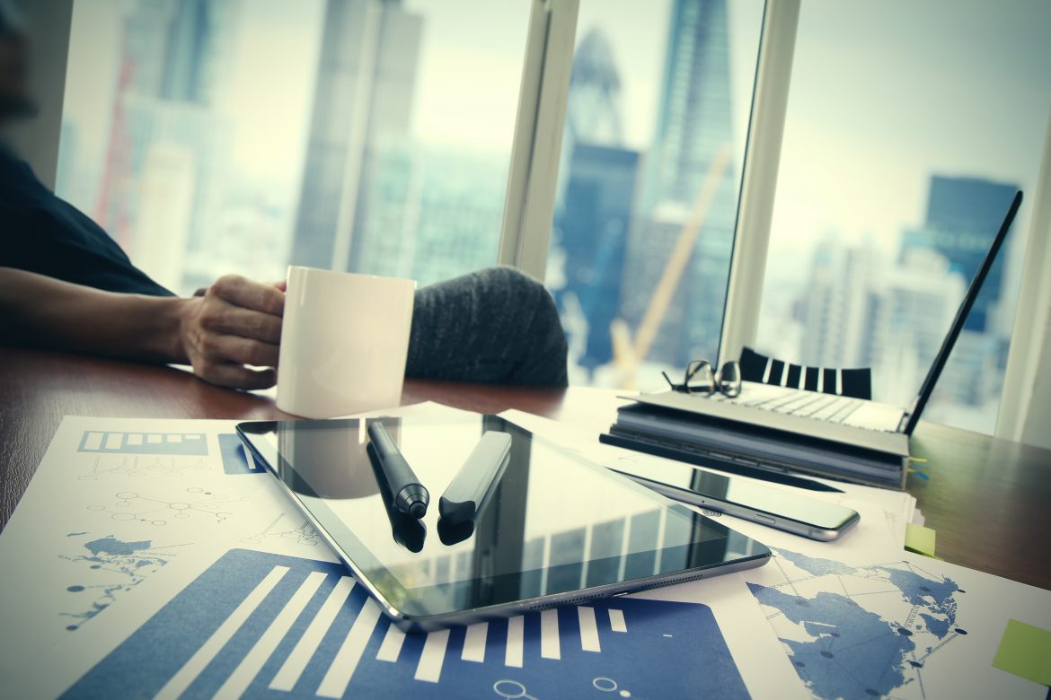 A businessman in his office with the London skyline in the background