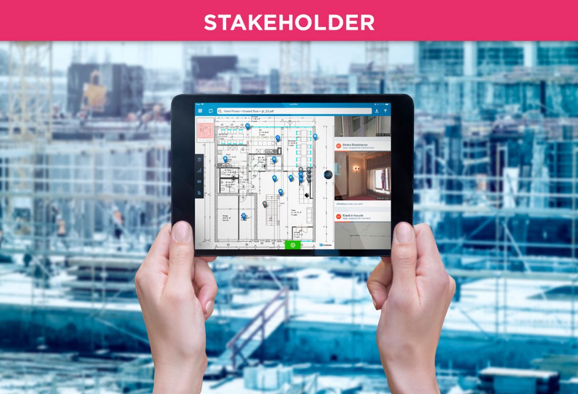 A person holding a tablet in front of a construction backdrop